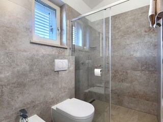 Badezimmer mit begehbarer Dusche und Toilette