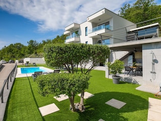 Garden with pool and outdoor kitchen in luxury villa