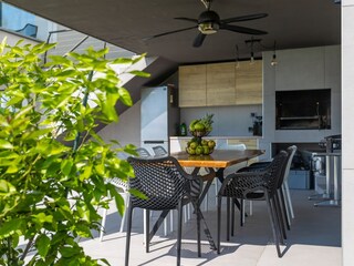 Überdachte Außenküche mit Esstisch in Villa Lavinia