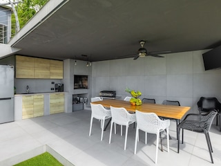 Covered outdoor kitchen with TV in holiday villa