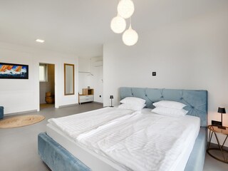 Schlafzimmer mit Doppelbett und eigenem Bad