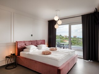 Modernes Schlafzimmer mit Doppelbett und Balkon