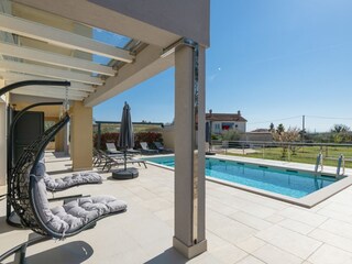 Außenbereich mit privatem Pool und Sonnenliegen