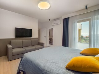 Bedroom with double bed, sofabed & TV in villa in Pula