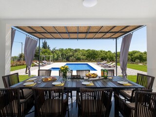 Außenbereich zum Essen mit Blick auf den Pool der Villa