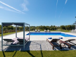 Sun loungers next to the pool of private villa