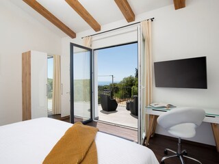 Comfortable bedroom with TV and terrace access