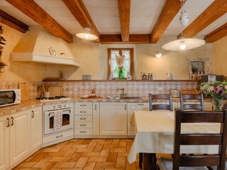 Kitchen with dining area, stone walls and wooden beams