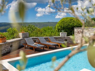 Sun loungers beside private pool with views of Raša Bay