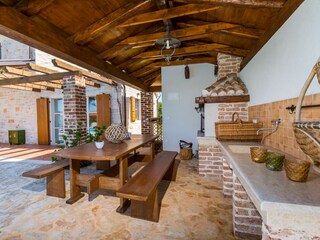 Covered BBQ area with dining table in villa in Porec