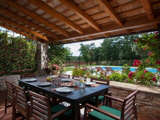 Covered outdoor dining area next to the pool