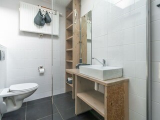 Badezimmer mit Dusche, Waschbecken und Toilette