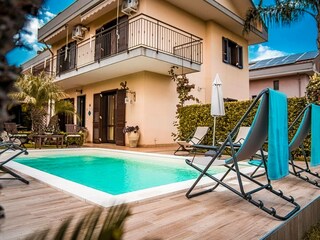 Pool mit Sonnenliegen und Gartenblick