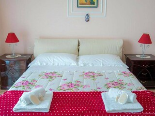 Doppelbett mit Blumenbettwäsche