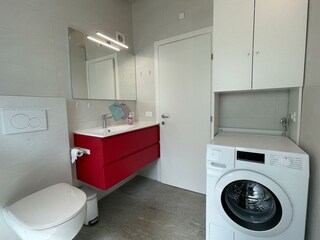 Badezimmer mit Dusche und Waschmaschine