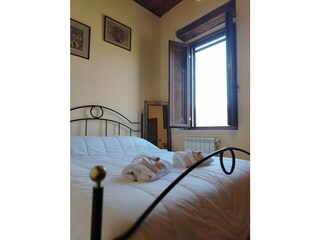 Helles Schlafzimmer mit geöffnetem Fenster und Blick in