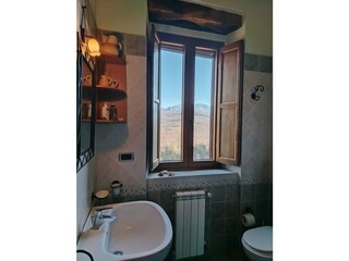 Helles Badezimmer mit Fenster und freiem Blick auf die