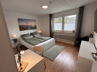 Schlafzimmer 1 mit Doppelbett und Schreibtisch