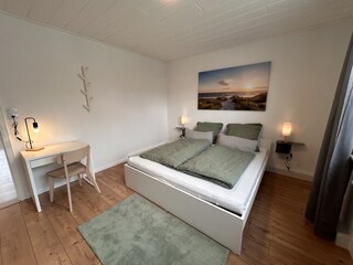 Schlafzimmer 1 mit Doppelbett und Schreibtisch