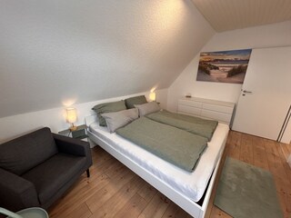 Schlafzimmer 3 mit Doppelbett, Sessel und Bad