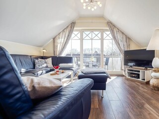 Wohnbereich mit Sofa, Sessel und TV