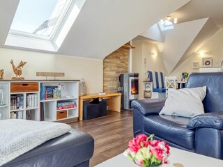 Wohnbereich mit Sessel und Blick zum Kamin