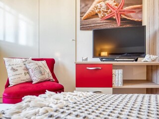 Blick zum TV und Sessel im Schlafzimmer