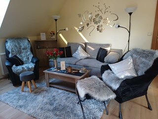 Ein gemütliches Wohnzimmer mit einem grauen Sofa, einem höhenverstellbaren Tisch