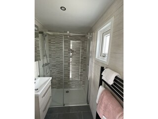 Badezimmer mit begehbarer Dusche, Waschbecken und WC