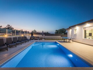Blue pool of villa at nighttime
