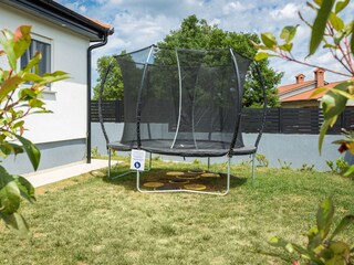Trampoline for kids in garden of villa