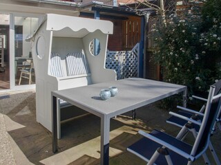 Sonnige Terrasse mit Strandkorb