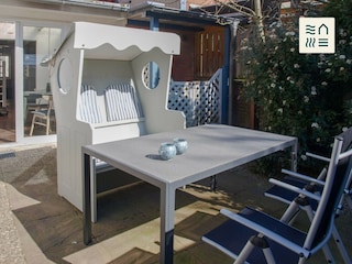 Sonnige Terrasse mit Strandkorb