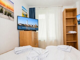 Schlafzimmer mit Kommode und TV