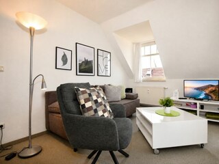 Wohnzimmer mit Sessel und TV