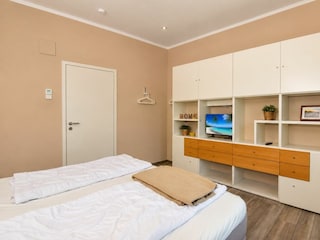2. Schlafzimmer mit Boxspringbett und TV