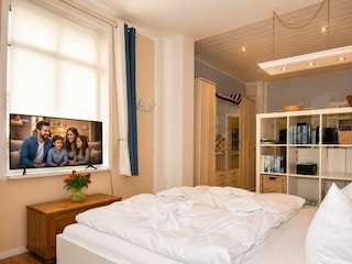 Wohnbereich mit Doppelbett und TV