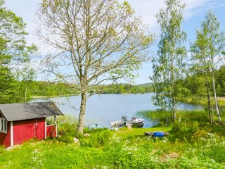 Links das Saunahäuschen am See; rechts der Steg