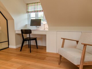 Im Obergeschoss befindet sich ein Arbeitsplatz für Holiday Home Office ...