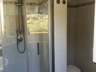 Bad 1 mit Dusche, WC und Waschbecken und Fenster