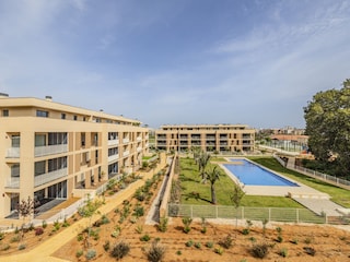 Blick vom Balkon auf den Aussenbereich mit Pool