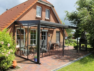 Überdachte Terrasse mit Sonnenschutzrollo u. Kamingrill