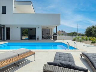 Pool mit Blick auf Wohnzimmer und Sitzecke auf Terrasse