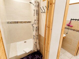 Dusche im Badezimmer mit Badewanne