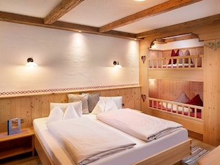 Schlafzimmer mit Doppelbett und Stockbett