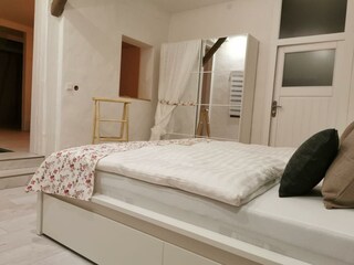 Schlafzimmer mit Doppelbett und Kleiderschrank