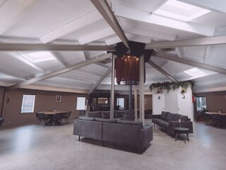 Round hall with wood stove and sofas