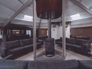 Round hall with wood stove and sofas