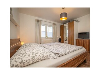 Schlafzimmer mit geräumigem Schrank und TV