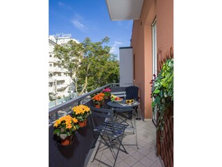 Balkon mit einem Tisch, zwei Stühlen und zwei Sesseln.
